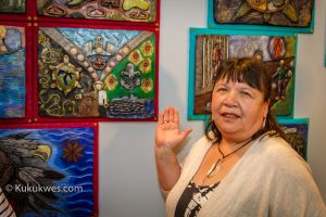Debbie Eisan, community events planner at the Mi'kmaw Native Friendship Centre, stands by the tile she created/Photo by Stephen Brake